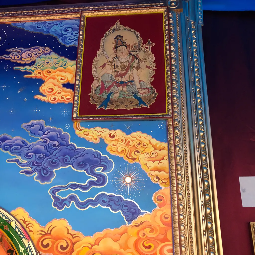 Detail: a Tara painting set among blue and golden clouds